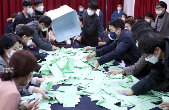 지난달 7일 부산시선거관리위원회 대회의실에서 열린 ‘4월15일 국회의원선거 모의 개표 시연회’에 참석한 선관위 직원들이 투표용지를 분류하고 있다. 선관위 직원들은 신종 코로나바이러스 예방을 위해 전원 마스크를 착용했다. /연합뉴스 